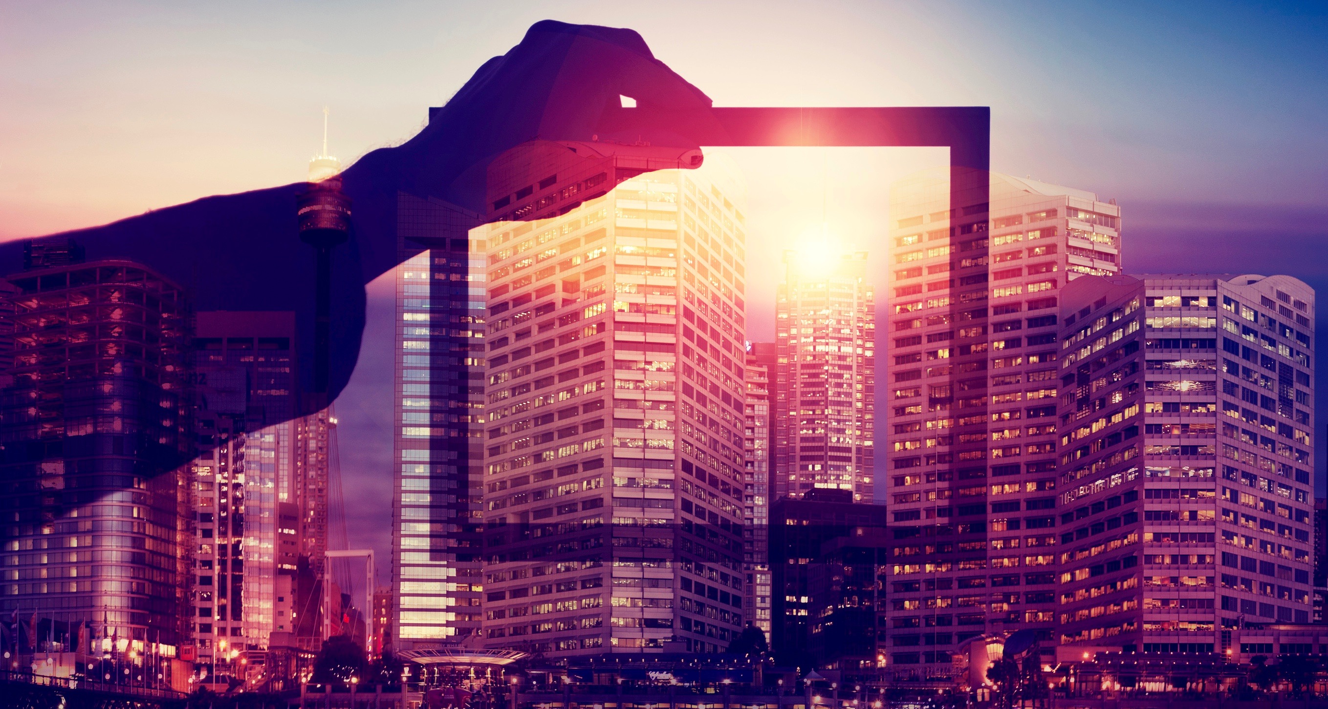 Business man holding a picture frame over city.